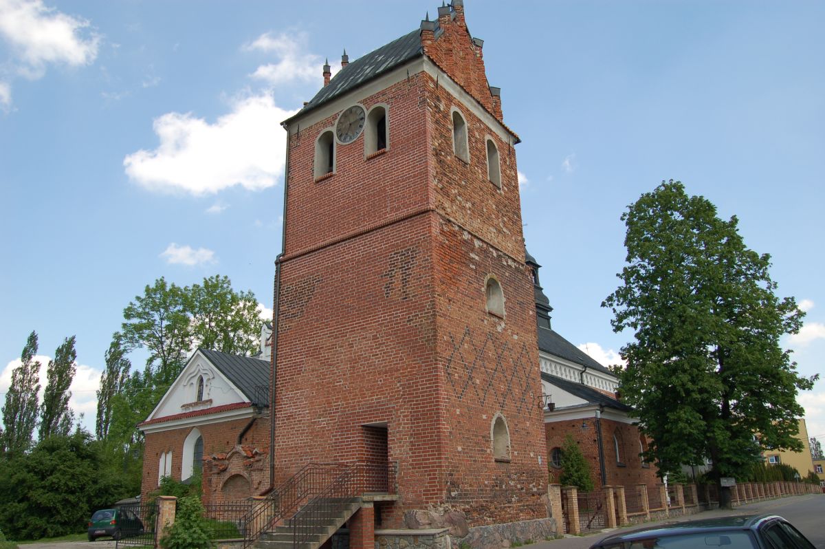 Wolnostojąca gotycka dzwonnica przy farze w Przasnyszu o zmierzchu